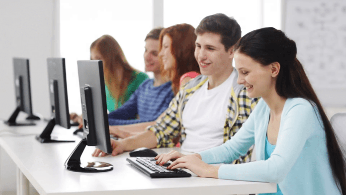 education-technology-school-and-people-concept-group-of-smiling-students-working-with-computers-in-computer-class-at-school_vuletns3e__F0000