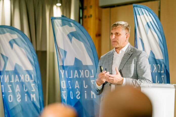 KZ Krzysztof Zawadzki na scenie, w tle flagi zjazdu miśot